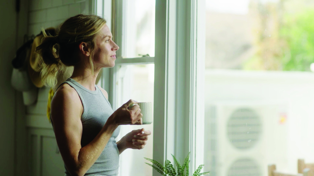 Woman near window with heat pump outside