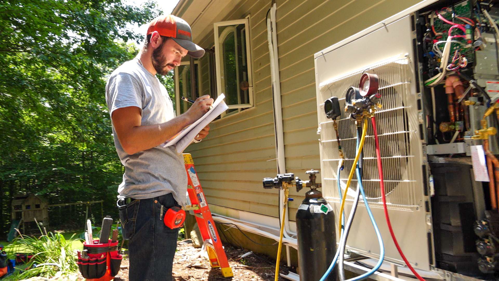 HVAC technician checking outdoor air conditioner