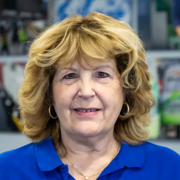 Blonde woman smiling indoors wearing blue shirt