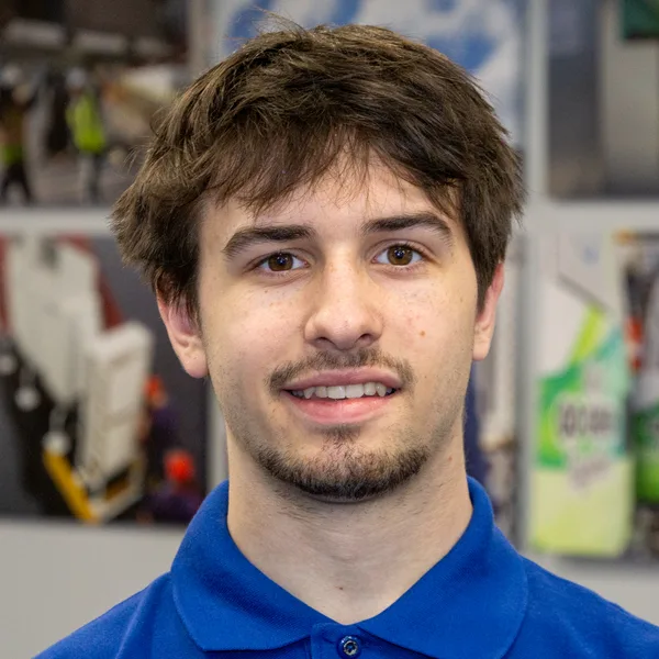 young man smiling in blue polo shirt